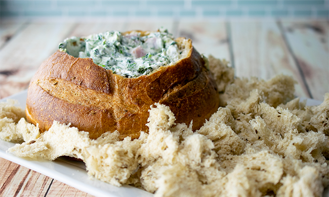 (Culinary.net) Perfect for afternoon snacking or as an appetizer, this Spinach-Ham Dip is warmed inside a bread bowl and can be served with bread cubes, crackers or tortilla chips.