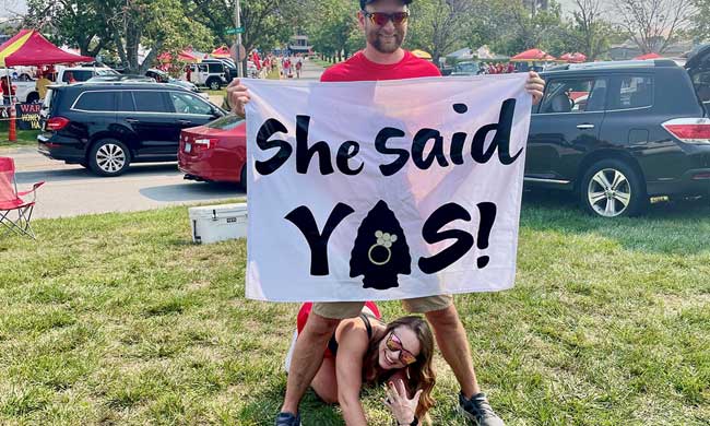 Jordyn Burnidge and Chad Clauser with sign "she said yes"